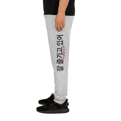 Grey heather joggers with the text 'Enjoying it' in English and Hangul in big print on the left leg